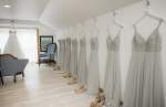 Bridesmaid's dresses hangin on hooks along the wall
