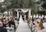 Couple standing under pergola saying vows