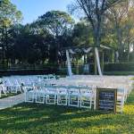 chairs set up on a lawn facing a pergola